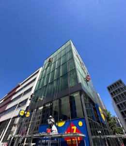 Vue d'ensemble de la façade vitrée d'un commerce à Lyon, cordistes en intervention sur toute la hauteur du bâtiment
