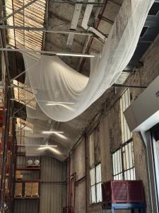 Filet de sécurité sur mesure installé sous charpente d'entrepôt industriel